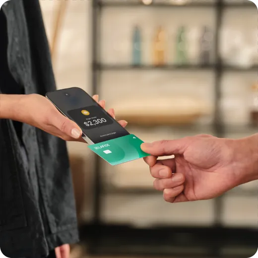 Un cliente paga con su tarjeta en una tienda de ropa usando Tap to Pay en iPhone.